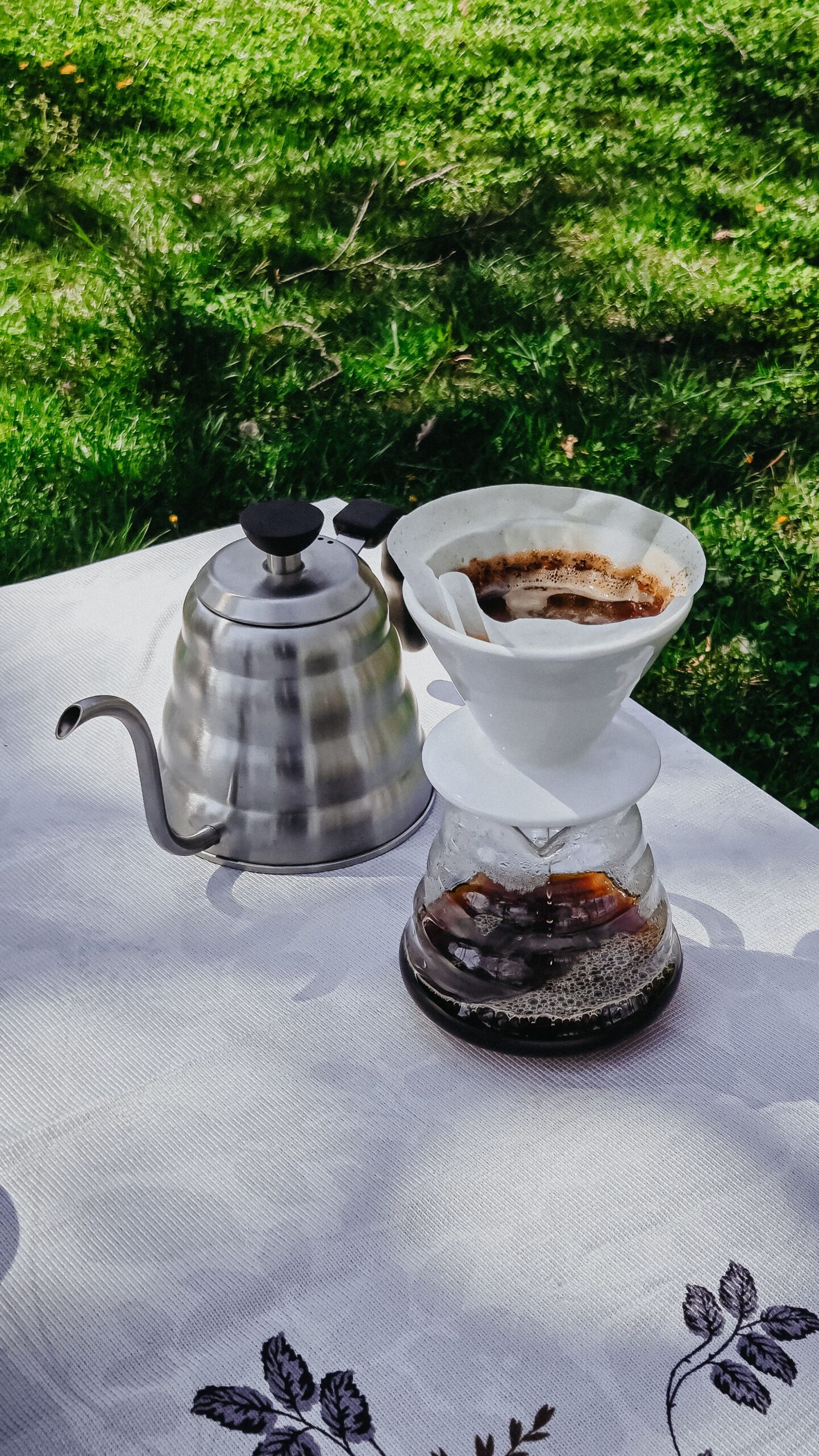 屋外のテーブルでドリップコーヒーを淹れている様子